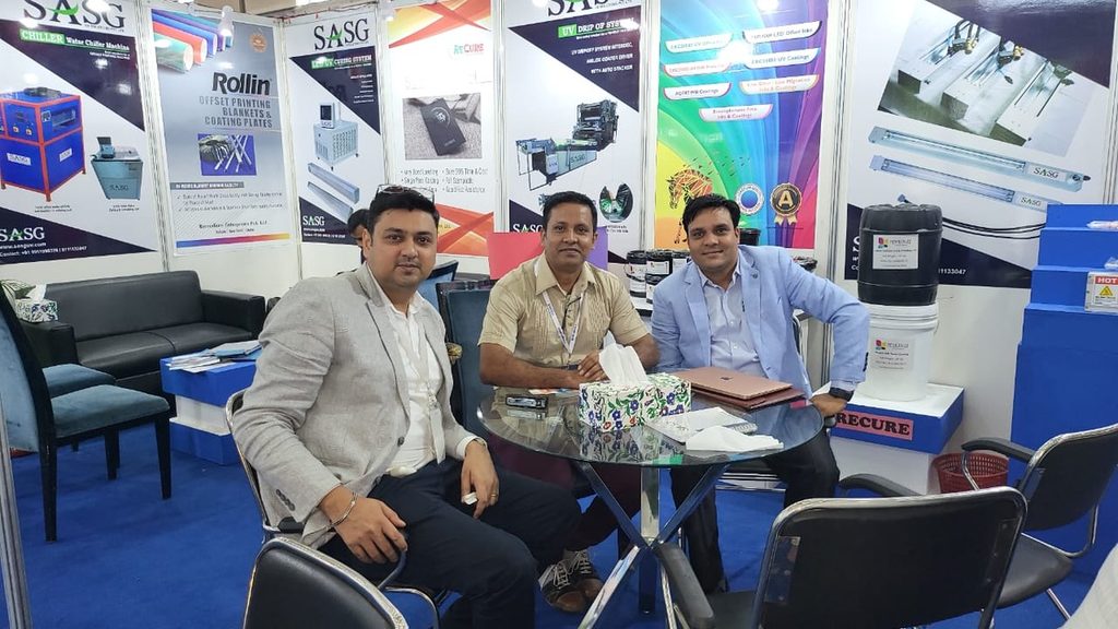 Remedium representatives at Bangladesh Print & Pack booth with offset blanket and UV curing displays